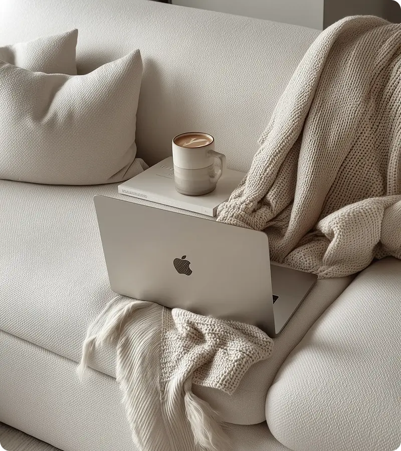Laptop and mug on soft sofa