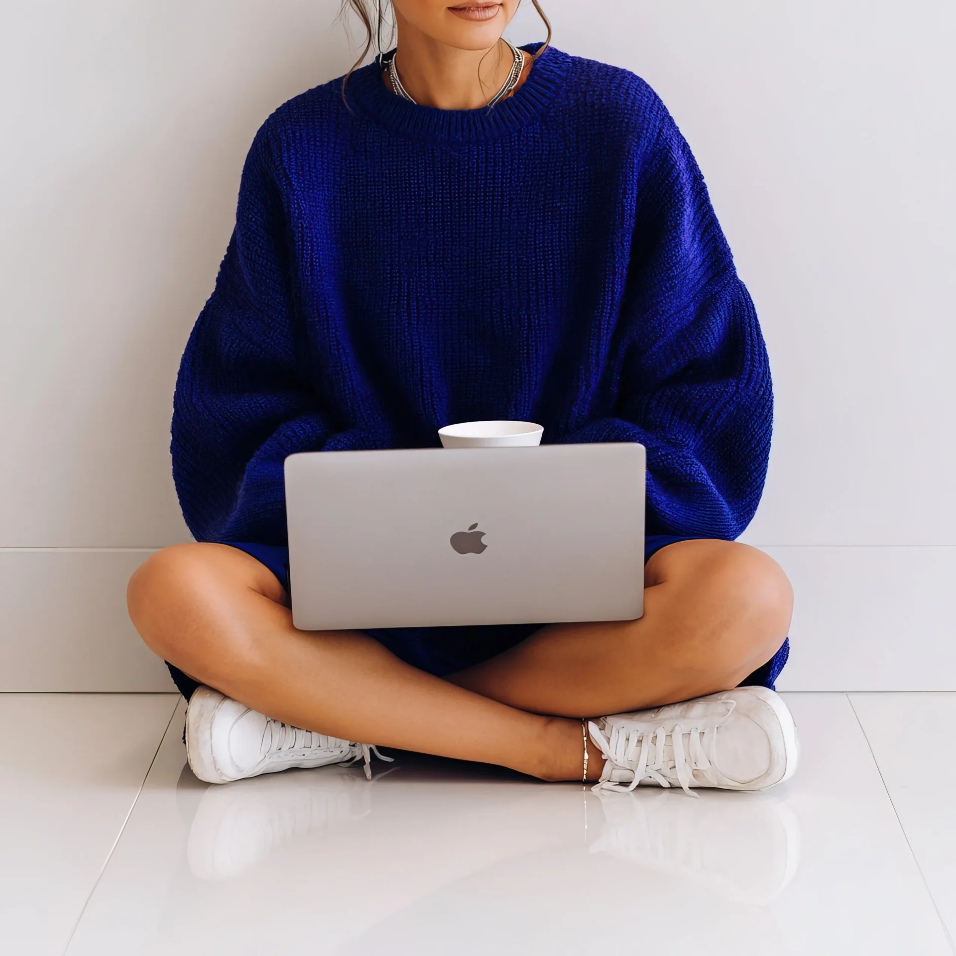 Woman in blue sweater with laptop